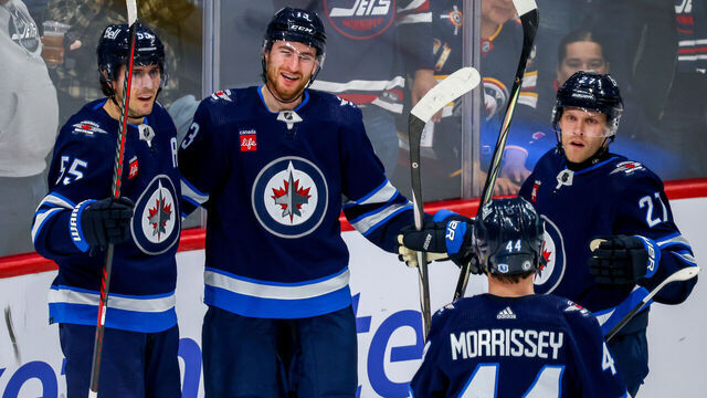 WINNIPEG, CANADA - APRIL 04: Mark Scheifele #55, Gabriel Vilardi #13, Nikolaj Ehlers #27, and Josh Morrissey #44 of the Winnipeg Jets celebrate third period goal against the Calgary Flames at Canada Life Centre on April 04, 2024 in Winnipeg, Manitoba, Canada.