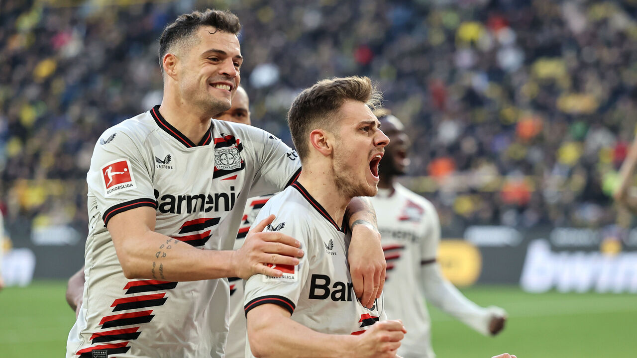 DORTMUND, GERMANY - APRIL 21: Josip Stanisic of Bayer Leverkusen celebrates scoring his team's first goal with teammate Granit Xhaka during the Bundesliga match between Borussia Dortmund and Bayer 04 Leverkusen at Signal Iduna Park on April 21, 2024 in Dortmund, Germany.