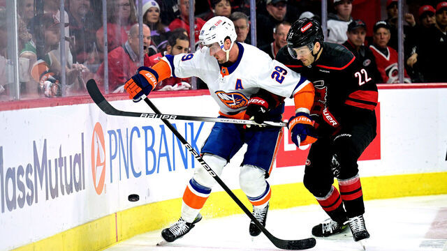 RALEIGH, NORTH CAROLINA - APRIL 22: Brock Nelson #29 of the New York Islanders battles Brett Pesce #22 of the Carolina Hurricanes for the puck during the second period in Game Two of the First Round of the 2024 Stanley Cup Playoffs at PNC Arena on April 22, 2024 in Raleigh, North Carolina.