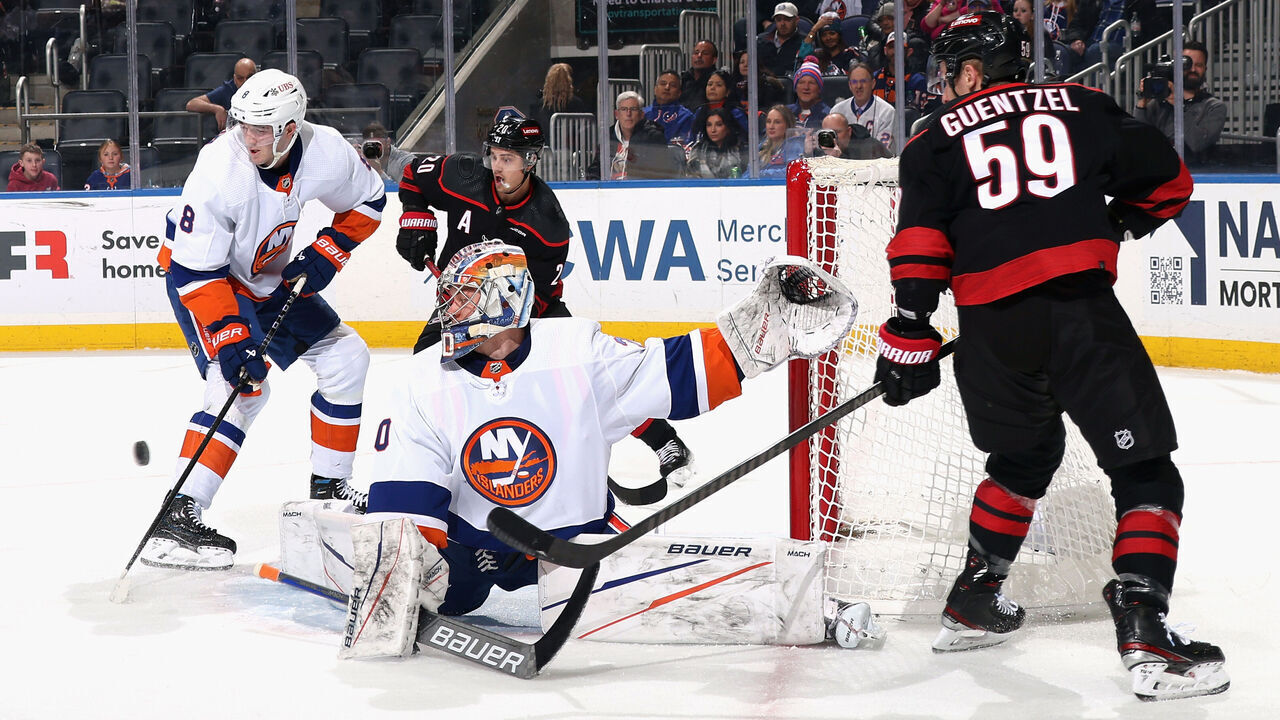ELMONT, NEW YORK - MARCH 19: The New York Islanders defend against Sebastian Aho #20 and Jake Guentzel #59 of the Carolina Hurricanes during the first period at UBS Arena on March 19, 2024 in Elmont, New York.