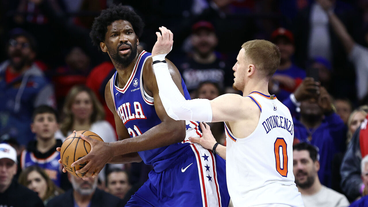 PHILADELPHIA, PENNSYLVANIA - APRIL 25: Joel Embiid #21 of the Philadelphia 76ers is guarded by Donte DiVincenzo #0 of the New York Knicks during the fourth quarter of game three of the Eastern Conference First Round Playoffs at the Wells Fargo Center on April 25, 2024 in Philadelphia, Pennsylvania. NOTE TO USER: User expressly acknowledges and agrees that, by downloading and/or using this Photograph, user is consenting to the terms and conditions of the Getty Images License Agreement.