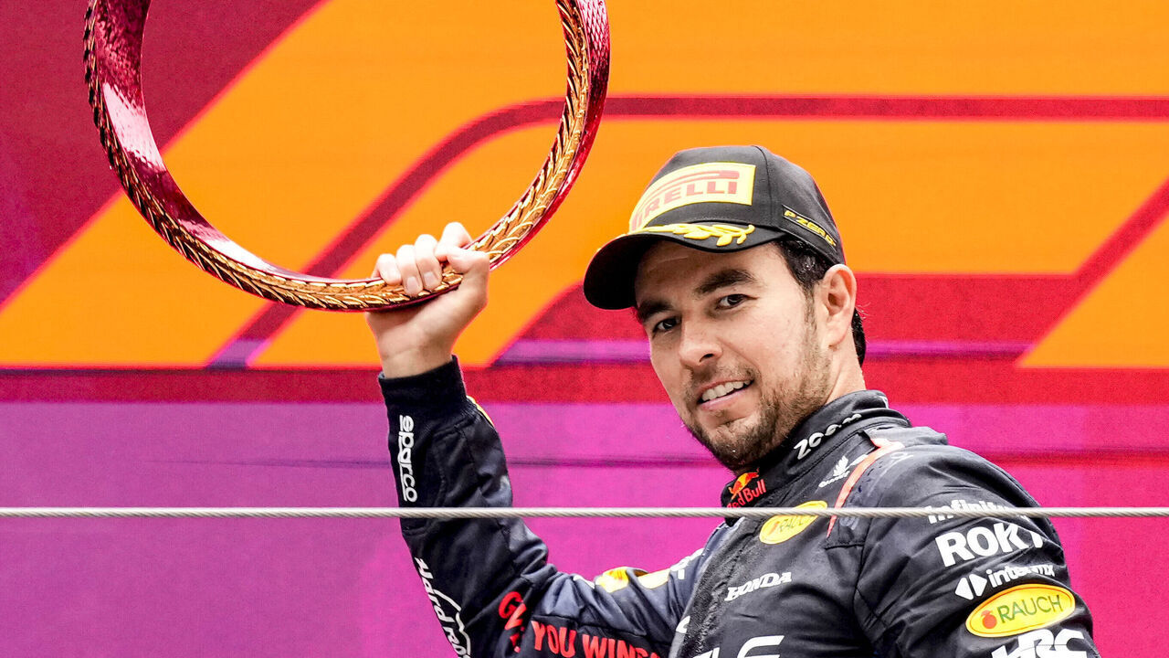 SHANGHAI, CHINA - APRIL 21: Third placed Sergio Perez of Mexico and Oracle Red Bull Racing celebrates with trophy on the podium during the F1 Grand Prix of China at Shanghai International Circuit on April 21, 2024 in Shanghai, China.