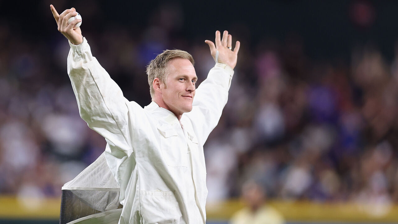 PHOENIX, ARIZONA - APRIL 30: Beekeeper Matt Hilton reacts to fans before throwing out the ceremonial first pitch during a delay to the MLB game between the Los Angeles Dodgers and the Arizona Diamondbacks at Chase Field on April 30, 2024 in Phoenix, Arizona. Tonights game has been delayed due to a bee colony that accumulated on the net behind home plate.