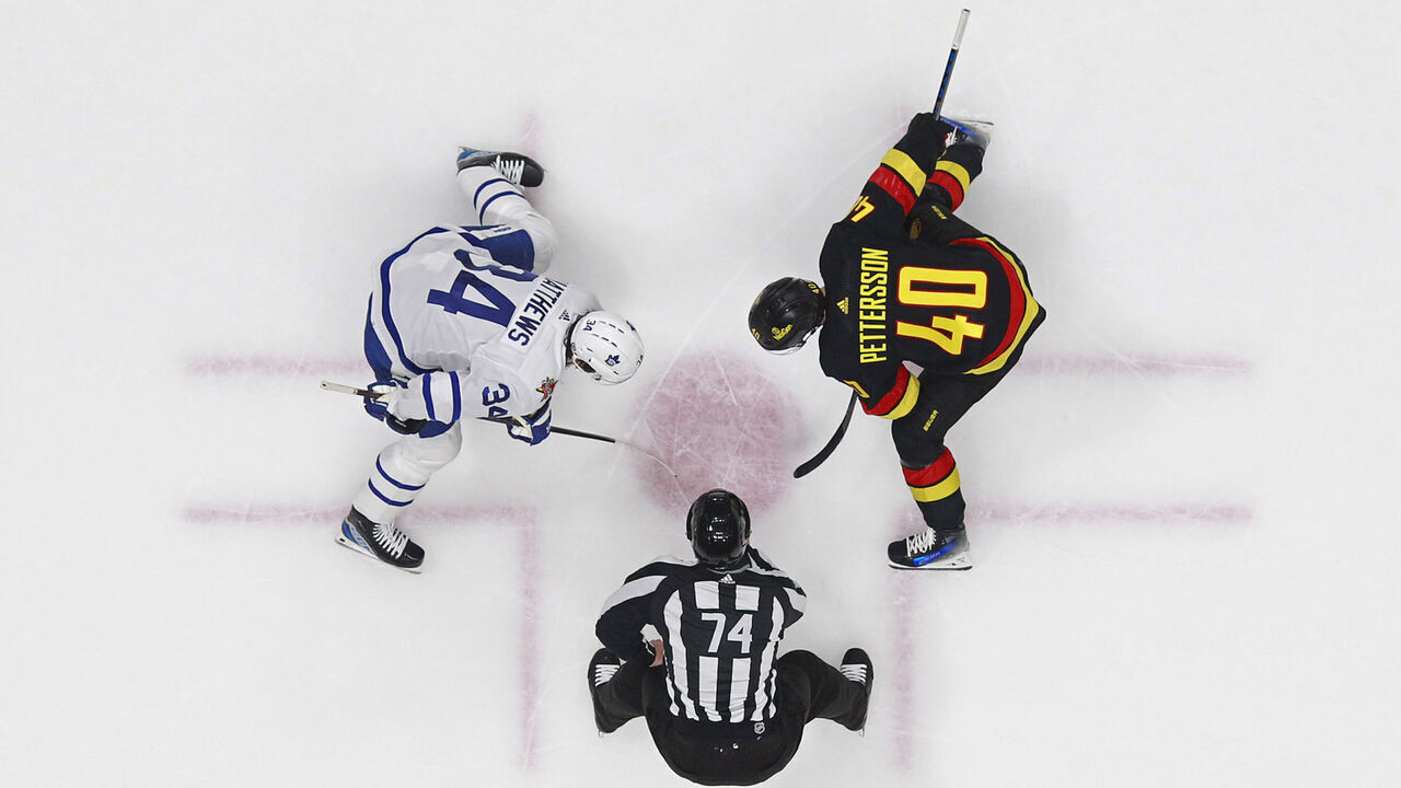 VANCOUVER, CANADA - JANUARY 20: Elias Pettersson #40 of the Vancouver Canucks and Auston Matthews #34 of the Toronto Maple Leafs line up for a face off during their NHL game at Rogers Arena on January 20, 2024 in Vancouver, British Columbia, Canada.