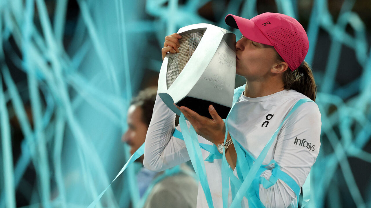 TOPSHOT - Poland's Iga Swiatek kises her trophy after beating Belarus' Aryna Sabalenka during the 2024 WTA Tour Madrid Open tournament final tennis match at Caja Magica in Madrid on May 4, 2024.