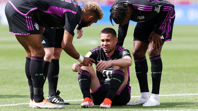 STUTTGART, GERMANY - MAY 04: Raphael Guerreiro of Bayern Munich is comforted by teammates after going down with an injury during the Bundesliga match between VfB Stuttgart and FC Bayern München at MHPArena on May 04, 2024 in Stuttgart, Germany.
