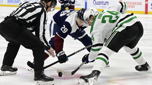 DENVER, CO - APRIL 07: Linesman Travis Gawryletz (67) drops the puck in a face-off between Colorado Avalanche center Nathan MacKinnon (29) and Dallas Stars center Roope Hintz (24) during the first period at Ball Arena in Denver, Colorado on Sunday, April 07, 2024.