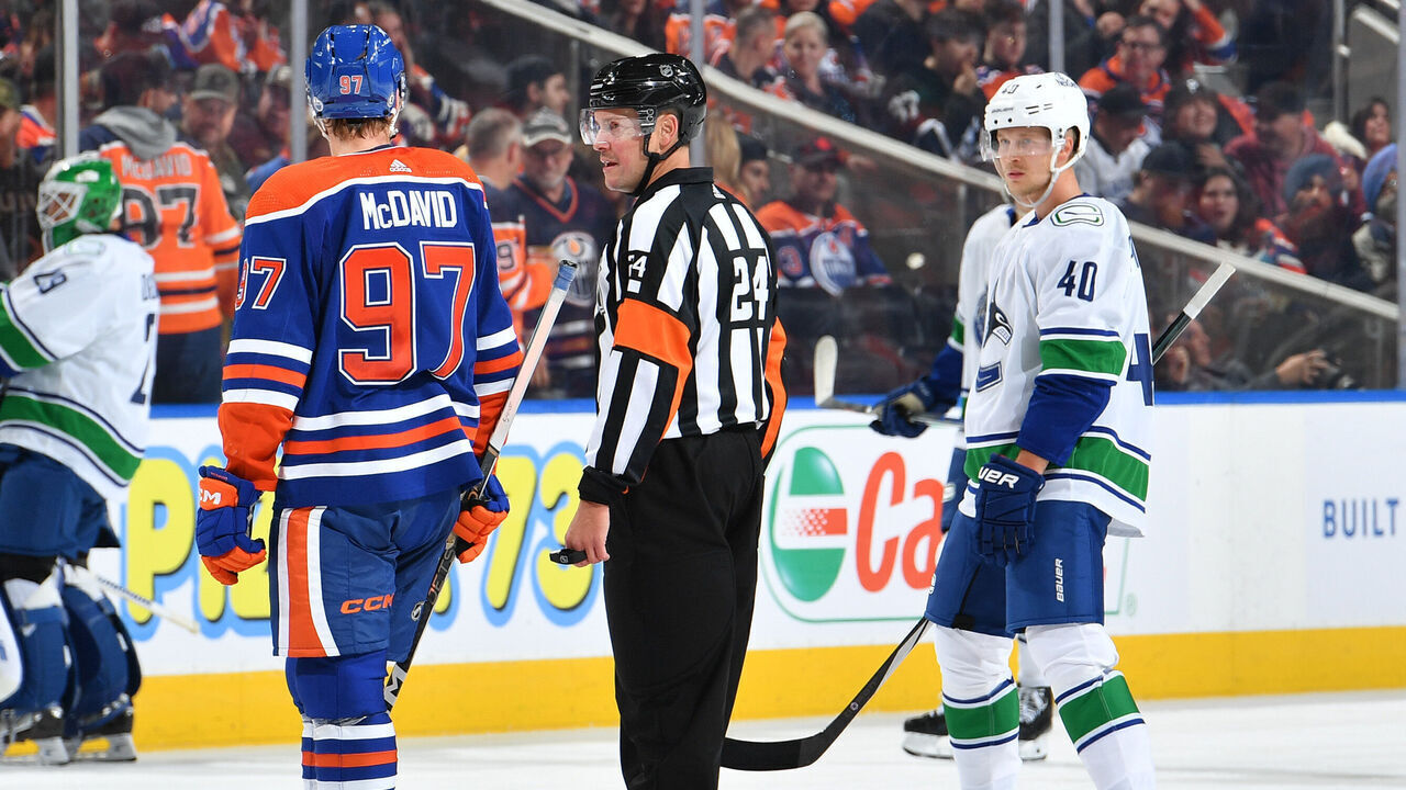 EDMONTON, CANADA - OCTOBER 14: Connor McDavid #97 of the Edmonton Oilers and Elias Pettersson #40 of the Vancouver Canucks exchange words during a stoppage in play during the game at Rogers Place on October 14, 2023, in Edmonton, Alberta, Canada.