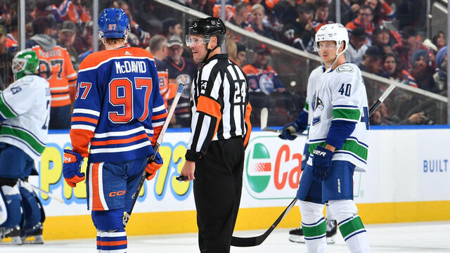 EDMONTON, CANADA - OCTOBER 14: Connor McDavid #97 of the Edmonton Oilers and Elias Pettersson #40 of the Vancouver Canucks exchange words during a stoppage in play during the game at Rogers Place on October 14, 2023, in Edmonton, Alberta, Canada.