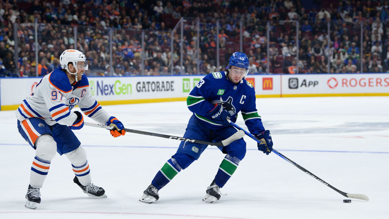 VANCOUVER, CANADA - OCTOBER 11: Quinn Hughes #43 of the Vancouver Canucks is checked by Connor McDavid #97 of the Edmonton Oilers during the third period of their NHL game at Rogers Arena on October 11, 2023 in Vancouver, British Columbia, Canada.