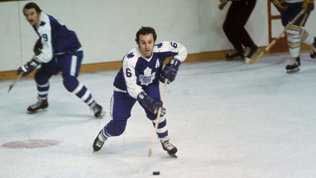 Canadian pro hockey player Ron Ellis (C) of the Toronto Maple Leafs controls the puck as teammate Norm Ullman skates behind him during a game against the Buffalo Sabres at the Aud, Buffalo, New York, early 1970s.