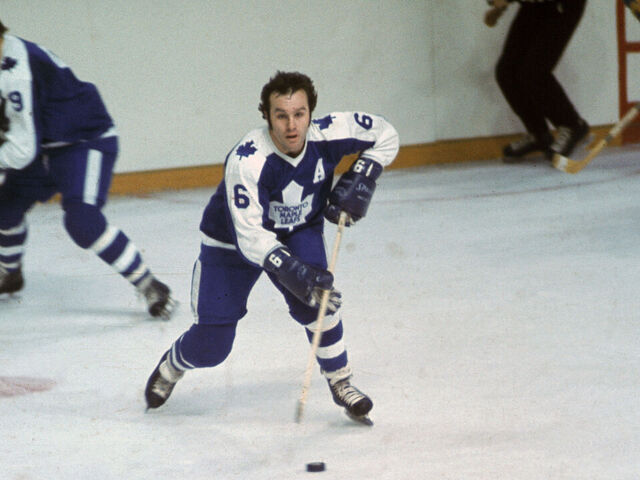 Canadian pro hockey player Ron Ellis (C) of the Toronto Maple Leafs controls the puck as teammate Norm Ullman skates behind him during a game against the Buffalo Sabres at the Aud, Buffalo, New York, early 1970s.