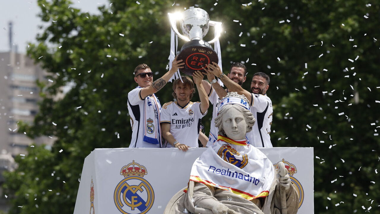 Real Madrid's German midfielder #08 Toni Kroos, Real Madrid's Croatian midfielder #10 Luka Modric, Real Madrid's Spanish defender #06 Nacho Fernandez and Real Madrid's Spanish defender #02 Dani Carvajal hold their 36th Liga trophy during celebration at the Cibeles square in Madrid on May 12, 2024. Real Madrid's fans line the streets of Madrid as 'Los blancos' celebrate their 36th Liga trophy before facing Borussia Dortmund at Wembley in the Champions League final on June 1.