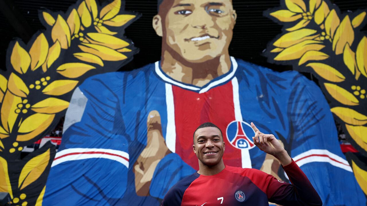 Paris Saint-Germain's French forward #07 Kylian Mbappe poses in front of a giant tifo before the French L1 football match between Paris Saint-Germain (PSG) and Toulouse (TFC) on May 12, 2024 at the Parc des Princes stadium in Paris. This game will be Mbappe's final home game after he confirmed on May 10 he will leave the French champions at the end of the season, with Real Madrid widely expected to be his next destination.