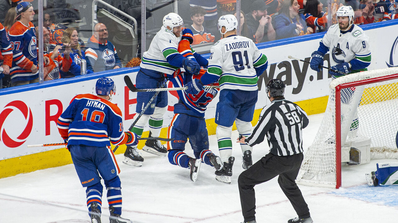 EDMONTON, ALBERTA - MAY 12: Connor McDavid #97 of the Edmonton Oilers gets crosschecked in the neck and back by Carson Soucy #7 and Nikita Zadorov #91 of the Vancouver Canucks during the third period in Game Three of the Second Round of the 2024 Stanley Cup Playoffs at Rogers Place on May 12, 2024 in Edmonton, Alberta, Canada.