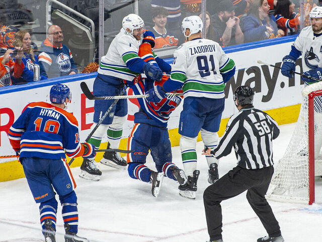 EDMONTON, ALBERTA - MAY 12: Connor McDavid #97 of the Edmonton Oilers gets crosschecked in the neck and back by Carson Soucy #7 and Nikita Zadorov #91 of the Vancouver Canucks during the third period in Game Three of the Second Round of the 2024 Stanley Cup Playoffs at Rogers Place on May 12, 2024 in Edmonton, Alberta, Canada.