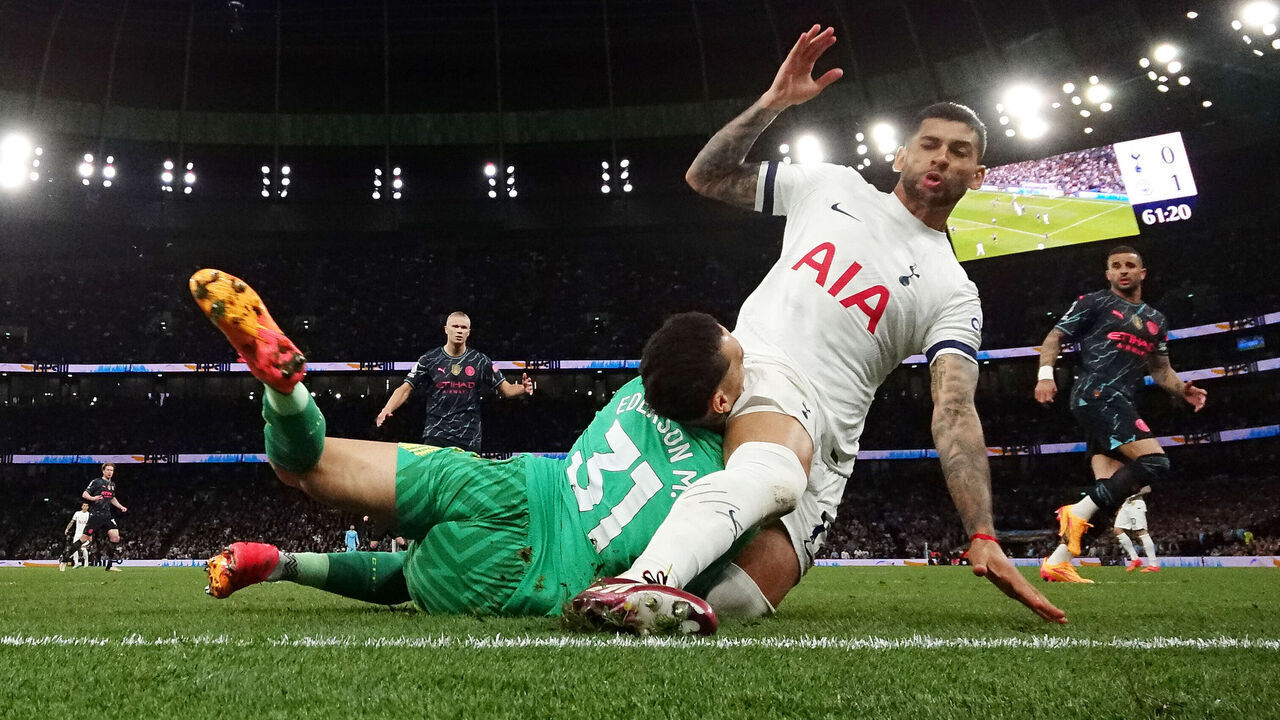 LONDON, ENGLAND - MAY 14: Cristian Romero of Tottenham Hotspur fouls Ederson of Manchester City, resulting in a yellow card leading to a injury for Ederson during the Premier League match between Tottenham Hotspur and Manchester City at Tottenham Hotspur Stadium on May 14, 2024 in London, England.