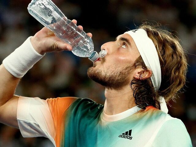 Greece's Stefanos Tsitsipas drinks water between the games against Russia's Daniil Medvedev during their men's singles semi-final match on day twelve of the Australian Open tennis tournament in Melbourne on January 28, 2022.