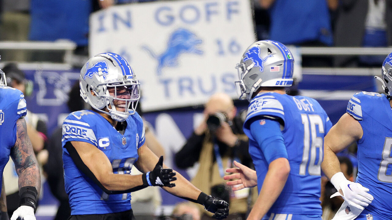 DETROIT, MICHIGAN - JANUARY 21: Amon-Ra St. Brown #14 of the Detroit Lions celebrates a touchdown with Jared Goff #16 while playing the Tampa Bay Buccaneers during a NFC Divisional Playoff game at Ford Field on January 21, 2024 in Detroit, Michigan.