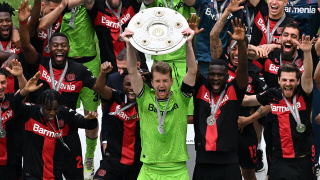 18 May 2024, North Rhine-Westphalia, Leverkusen: Soccer, Bundesliga, Bayer Leverkusen - FC Augsburg, Matchday 34, BayArena, Leverkusen goalkeeper Lukas Hradecky (m) celebrates with the championship trophy. IMPORTANT NOTE: In accordance with the regulations of the DFL German Football League and the DFB German Football Association, it is prohibited to use or have used photographs taken in the stadium and/or of the match in the form of sequential images and/or video-like photo series. Photo: David Inderlied/dpa