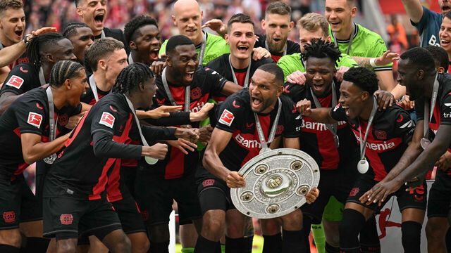 Bayer Leverkusen's German defender #04 Jonathan Tah and his teammates celebrate with the Bundesliga trophy after the German first division Bundesliga football match between Bayer 04 Leverkusen and FC Augsburg in Leverkusen, western Germany on May 18, 2024.