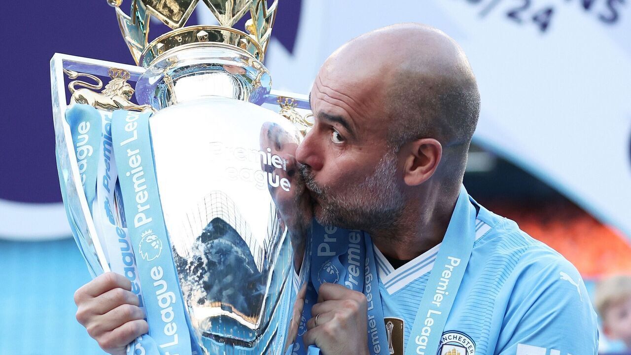 Manchester City's manager Pep Guardiola kisses the Premier League trophy after the English Premier League football match between Manchester City and West Ham United in Manchester, Britain, on May 19, 2024.