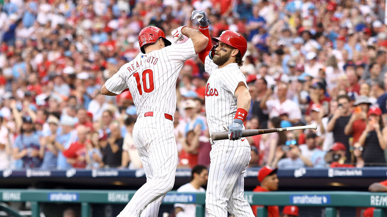 PHILADELPHIA, PENNSYLVANIA - MAY 22: J.T. Realmuto #10 and Bryce Harper #3 of the Philadelphia Phillies react following a solo home run by Realmuto during the third inning against the Texas Rangers at Citizens Bank Park on May 22, 2024 in Philadelphia, Pennsylvania.