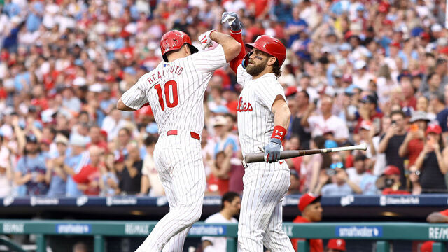 PHILADELPHIA, PENNSYLVANIA - MAY 22: J.T. Realmuto #10 and Bryce Harper #3 of the Philadelphia Phillies react following a solo home run by Realmuto during the third inning against the Texas Rangers at Citizens Bank Park on May 22, 2024 in Philadelphia, Pennsylvania.