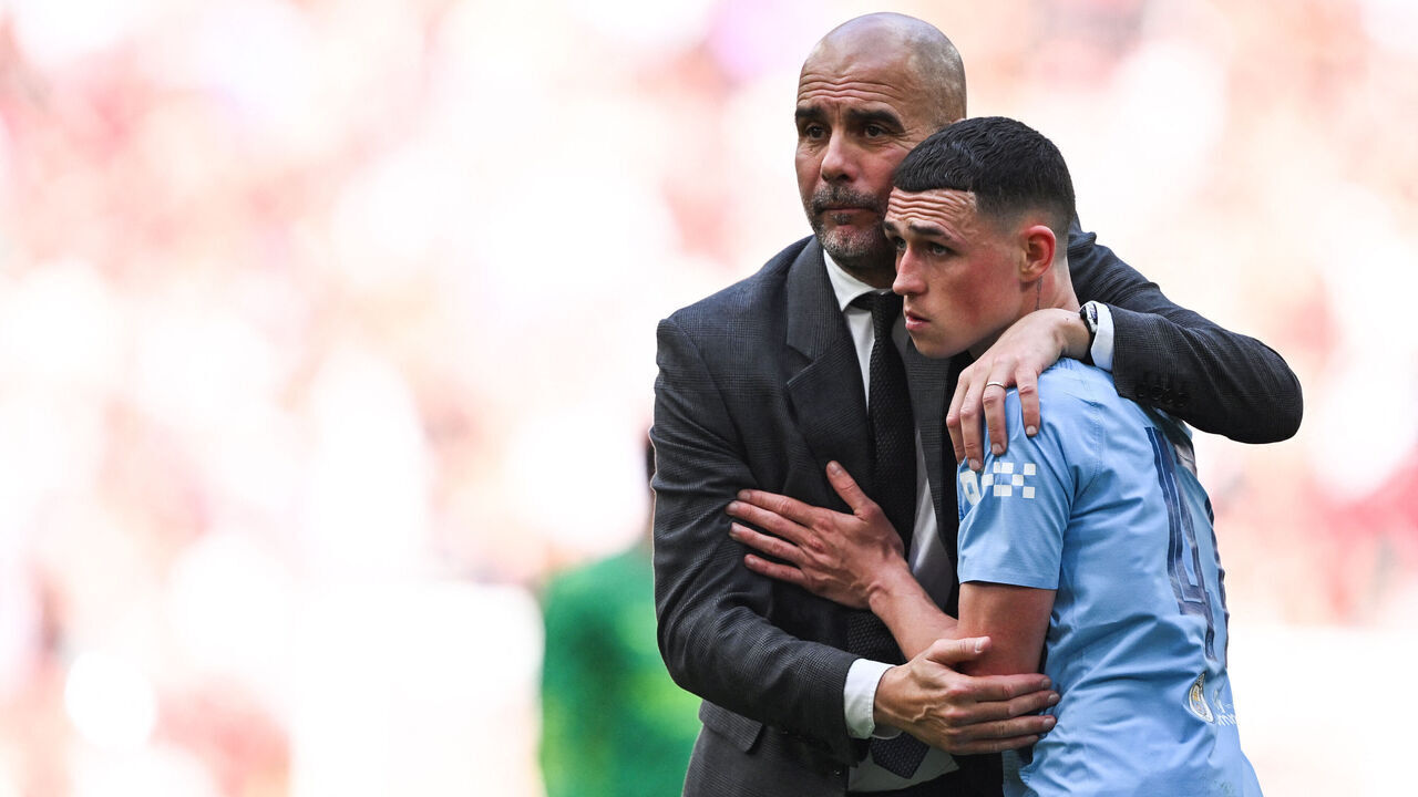 TOPSHOT - Manchester City's Spanish manager Pep Guardiola consols Manchester City's English midfielder #47 Phil Foden after loosing the English FA Cup final football match between Manchester City and Manchester United at Wembley stadium, in London, on May 25, 2024. Manchester United wins 2 - 1 against Manchester City.