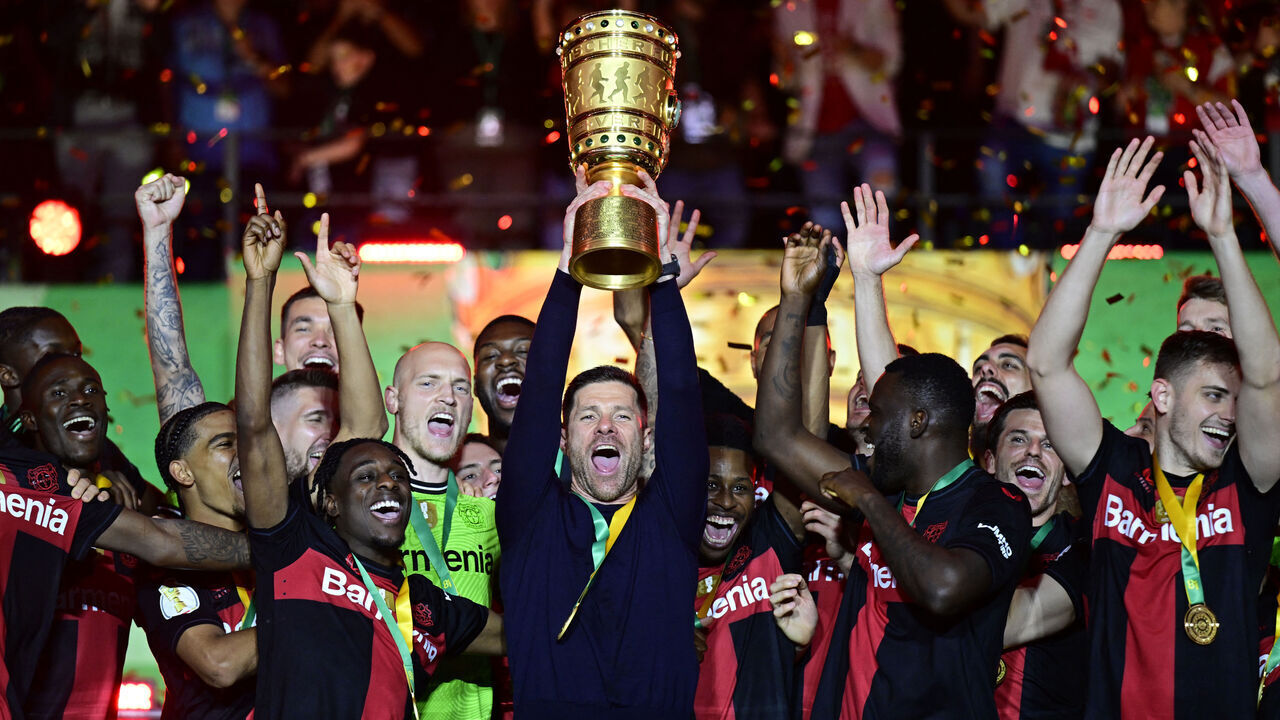Bayer Leverkusen's Spanish head coach Xabi Alonso celebrates with the trophy after winning the German Cup (DFB-Pokal) final football match between 1 FC Kaiserslautern and Bayer 04 Leverkusen at the Olympic Stadium in Berlin on May 25, 2024.