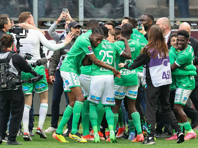 Saint-Etienne's players celebrate with supporters their victory at the end of the French L1-L2 playoff football match between FC Metz and AS Saint-Etienne at the Saint-Symphorien Stadium in Longeville-les-Metz, eastern France on June 2, 2024. The match ended 2-2 and Saint-Etienne will join again the L1.