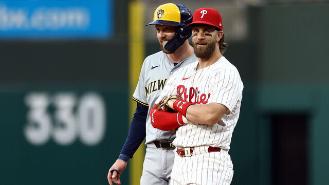 PHILADELPHIA, PENNSYLVANIA - JUNE 03: Rhys Hoskins #12 of the Milwaukee Brewers and Bryce Harper #3 of the Philadelphia Phillies speak during the fifth inning at Citizens Bank Park on June 03, 2024 in Philadelphia, Pennsylvania.
