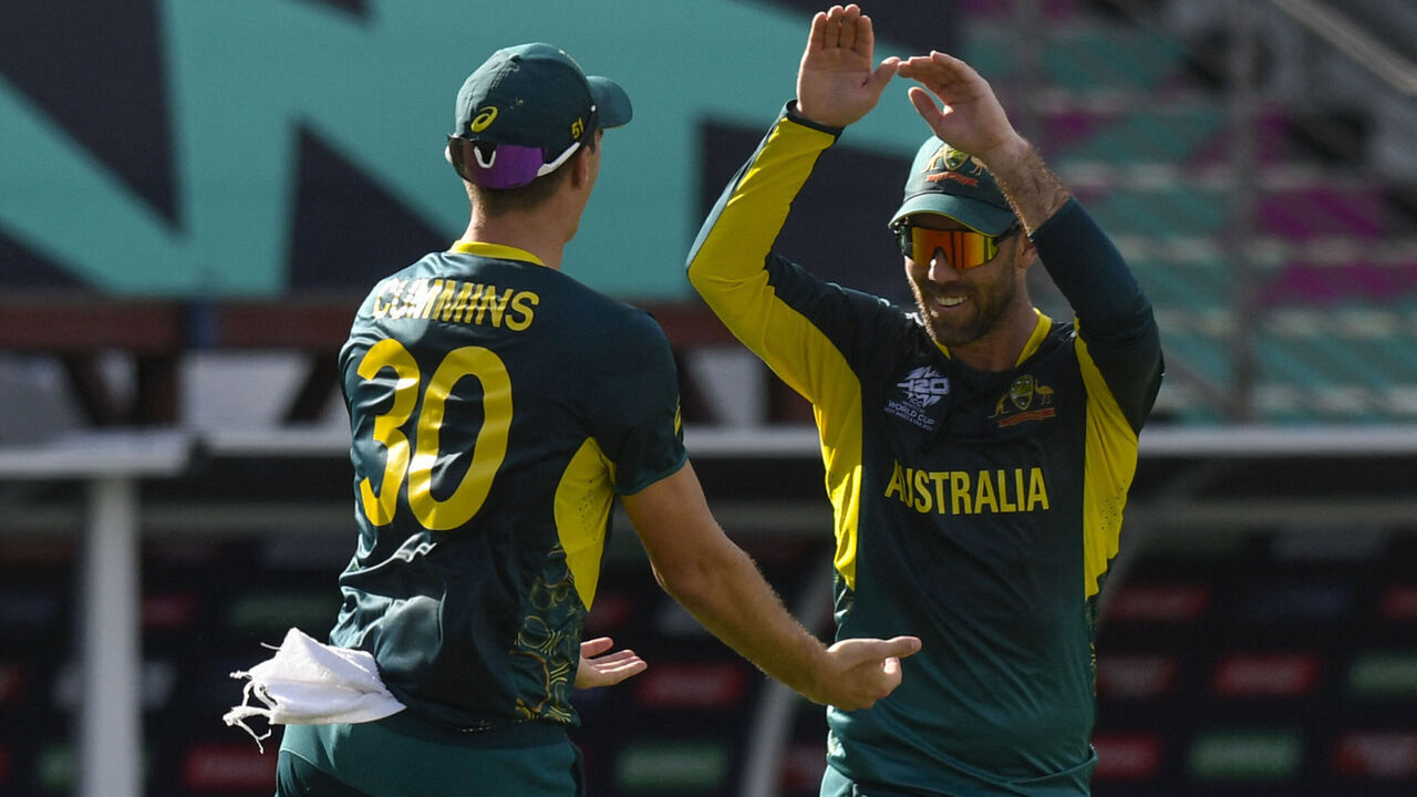 Australia's Glenn Maxwell (R) and Australia's Pat Cummins celebrate the dismissal of England's Jonathan Bairstow during the ICC men's Twenty20 World Cup 2024 group B cricket match between Australia and England at Kensington Oval in Bridgetown, Barbados, on June 8, 2024.