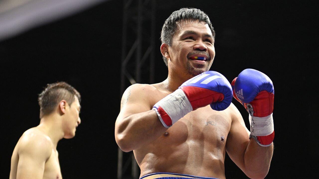 Manny Pacquiao (R) of the Philippines reacts after fighting against DK Yoo (L) of South Korea during their exhibition boxing match in Goyang, northwest of Seoul, on December 11, 2022.