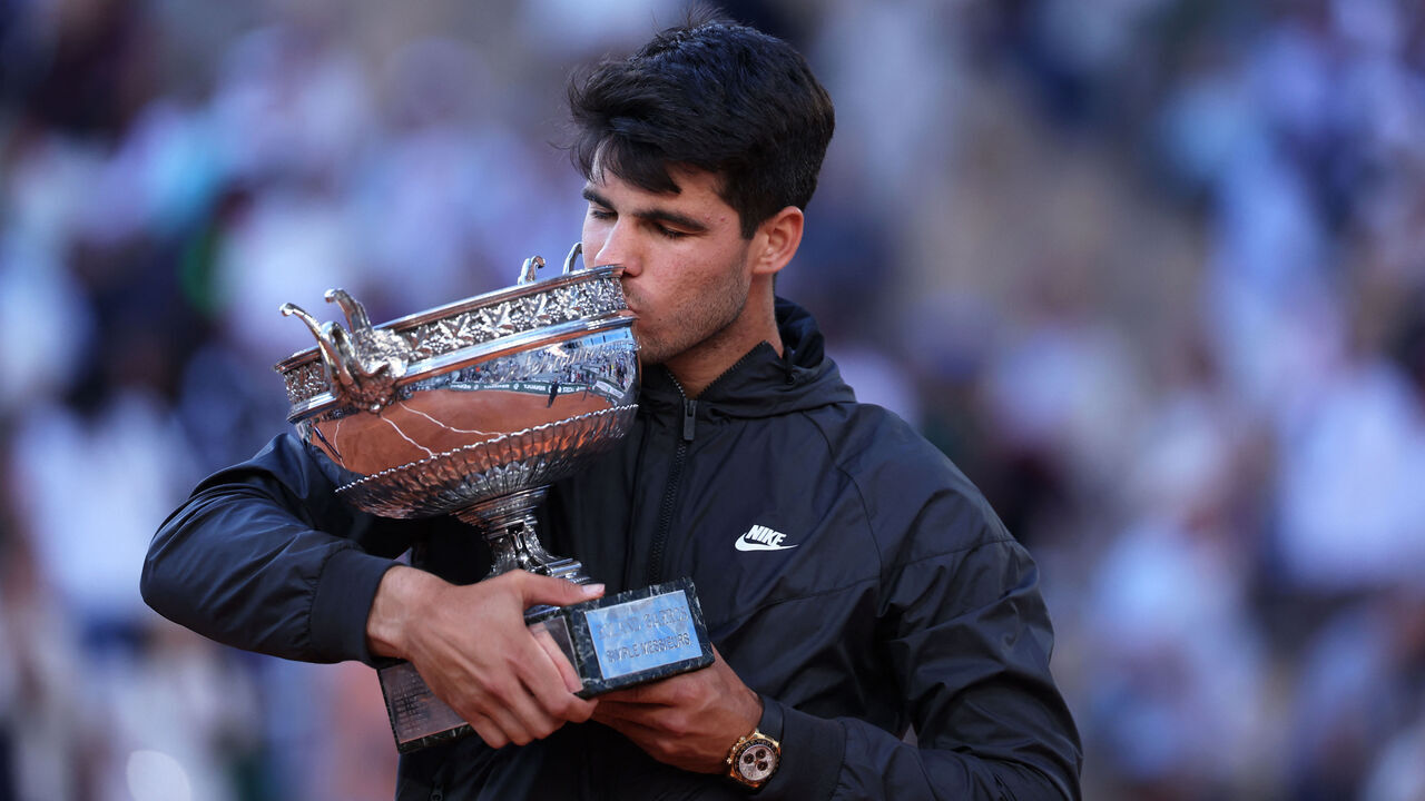 Spain's Carlos Alcaraz kisses the trophy after winning against Germany's Alexander Zverev in the men's singles final match on Court Philippe-Chatrier on day fifteen of the French Open tennis tournament at the Roland Garros Complex in Paris on June 9, 2024.