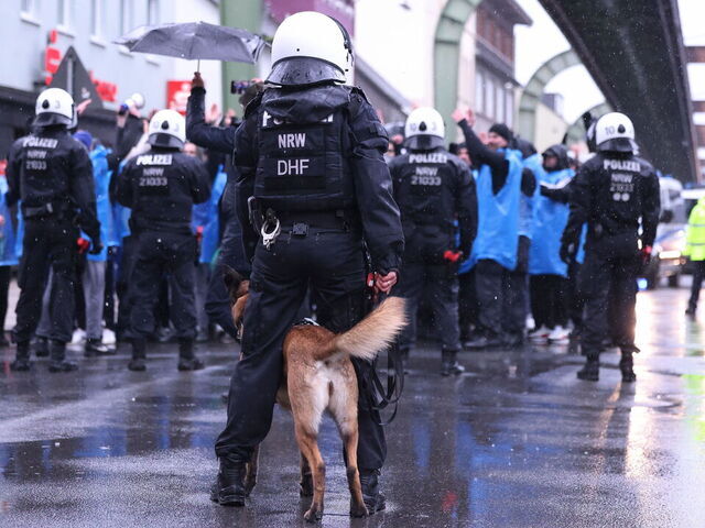 16 April 2024, North Rhine-Westphalia, Wuppertal: A police dog is used against violent soccer fans during a major exercise by the Wuppertal police. Around 250 members of the Wuppertal police force have been practising how to deal with violent soccer fans in the run-up to the European Football Championships this summer. Photo: David Young/dpa