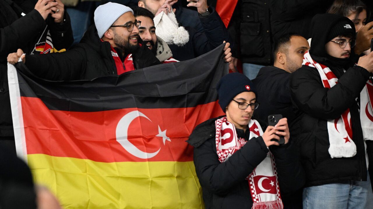 A fan holds flag, a mix of the German and Turkish flags, prior to the international friendly football match between Germany and Turkey at the Olympic Stadium in Berlin on November 18, 2023, in preparation for the UEFA Euro 2024 in Germany.