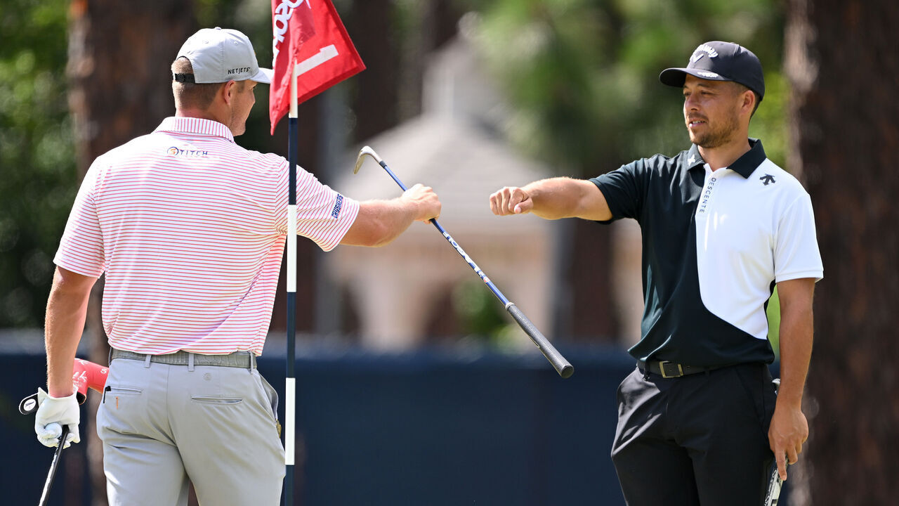 PINEHURST, NORTH CAROLINA - JUNE 10: (L-R) Bryson DeChambeau of the United States and Xander Schauffele of the United States fist bump on the first green during a practice round prior to the U.S. Open at Pinehurst Resort on June 10, 2024 in Pinehurst, North Carolina.