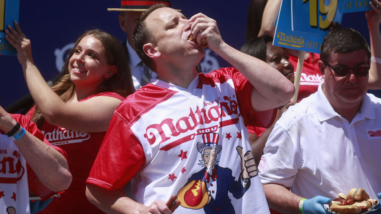 NEW YORK, NY - JULY 04: Joey Chestnut eats hot dogs during the 2022 Nathans Famous Fourth of July International Hot Dog Eating Contest on July 4, 2022 at Coney Island in the Brooklyn borough of New York City. The contest, which has happened every year since 1972, has returned in front of Nathan’s Famous on Surf Avenue this year.