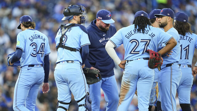 TORONTO, ON - JUNE 14: Kevin Gausman #34 of the Toronto Blue Jays gets taken out of the game by manager John Schneider alongside Vladimir Guerrero Jr. #27, Danny Jansen #9 and Isiah Kiner-Falefa #7 in a break in play against the Cleveland Guardians during the sixth inning in their MLB game at the Rogers Centre on June 14, 2024 in Toronto, Ontario, Canada.