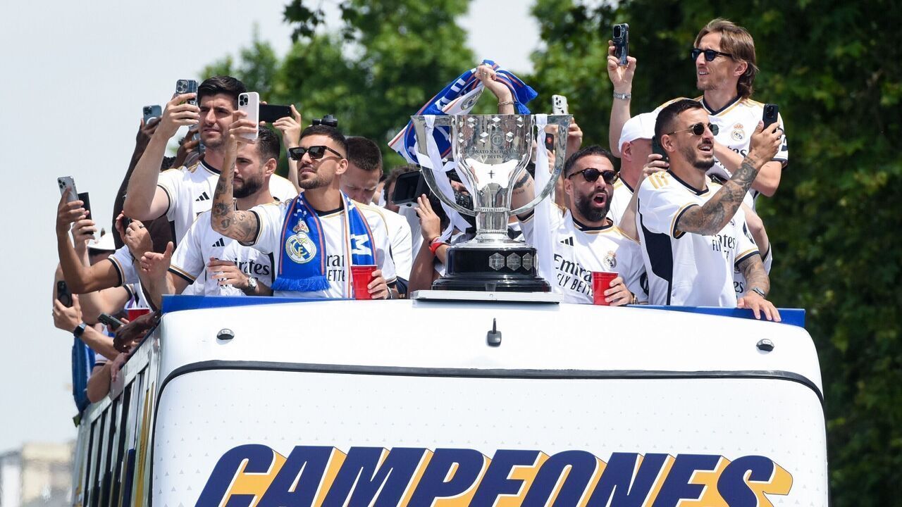 Players of Real Madrid celebrate with their trophy as they parade on a bus during a ceremony of Real Madrid's celebration after winning the champion of the 2023-2024 Spanish La Liga in Madrid, Spain, May 12, 2024.
