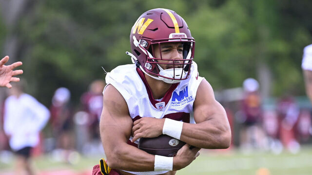 ASHBURN, VA - JUNE 12 : Washington Commanders running back Austin Ekeler, center, takes a handoff from from Commanders quarterback Jayden Daniels during mini camp at Commanders Park in Ashburn, VA on June 12, 2024.