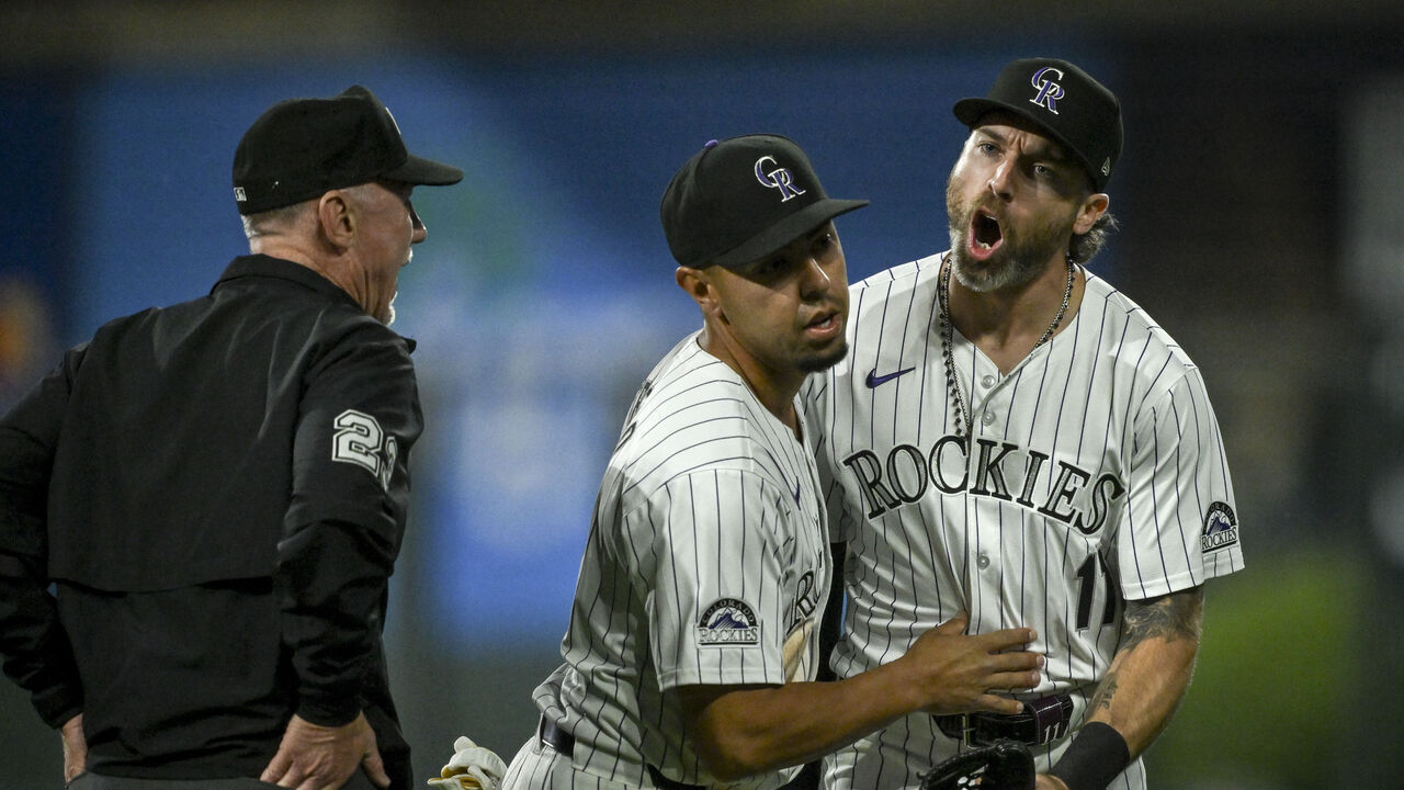 DENVER, CO - JUNE 18: Alan Trejo (13) holds back Jake Cave (11) of the Colorado Rockies as he argues with umpire Lance Barksdale (23) after the Los Angeles Dodgers scored seven runs in the top of the night inning during the Dodgers' 11-9 win at Coors Field in Denver on Tuesday, June 18, 2024.