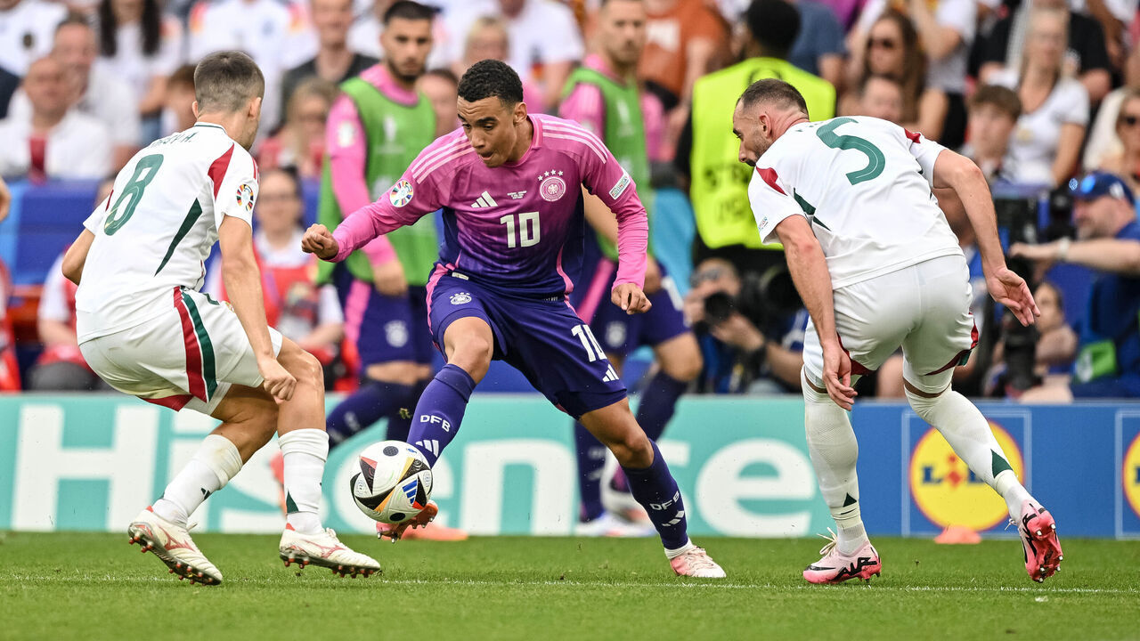 STUTTGART, GERMANY - JUNE 19: Ádám Nagy of Hungary, Jamal Musiala of Germany and Attila Fiola of Hungary battle for the ball during the UEFA EURO 2024 group stage match between Germany and Hungary at Stuttgart Arena on June 19, 2024 in Stuttgart, Germany.