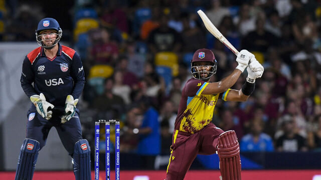 West Indies' Shai Hope hits a six as USA's Andries Gous (L) watches during the ICC men's Twenty20 World Cup 2024 Super Eight cricket match between USA and West Indies at Kensington Oval in Bridgetown, Barbados on June 21, 2024.