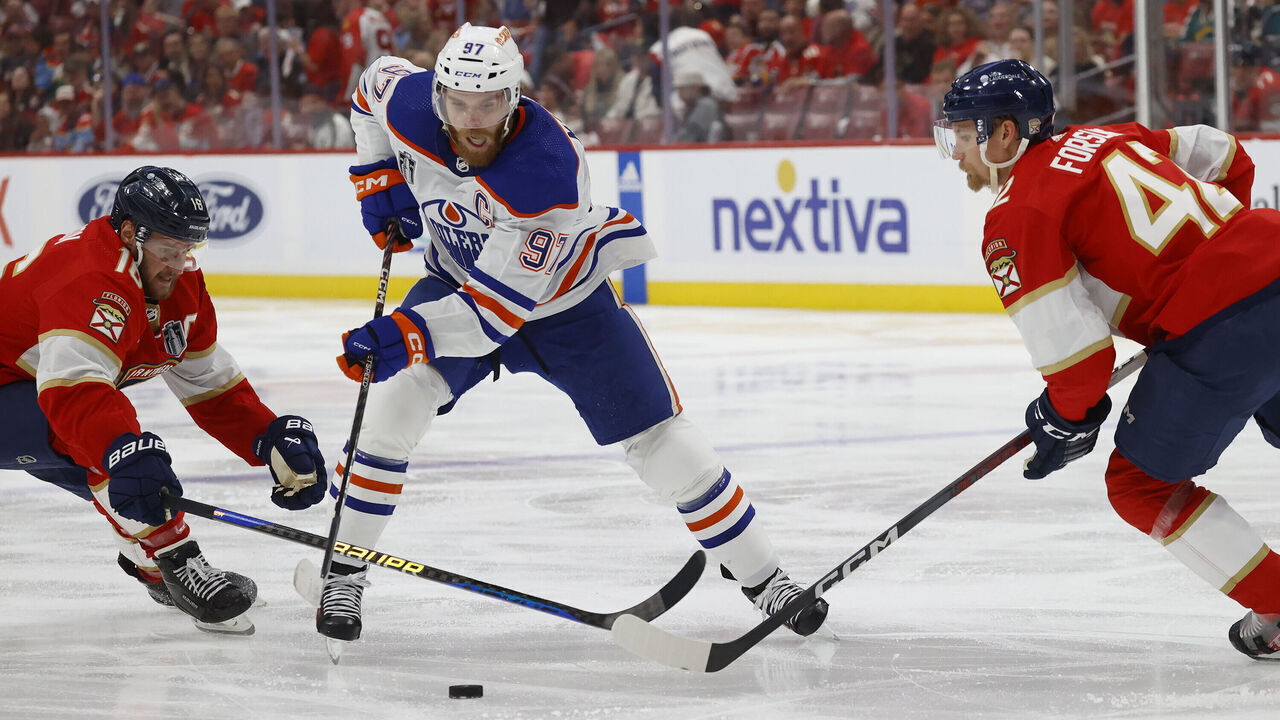SUNRISE, FLORIDA - JUNE 18: Connor McDavid #97 of the Edmonton Oilers skates between teammates Aleksander Barkov #16 and Gustav Forsling #42 of the Florida Panthers in Game Five of the Stanley Cup Final at the Amerant Bank Arena on June 18, 2024 in Sunrise, Florida.