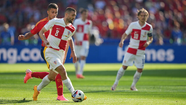 15 June 2024, Berlin: Soccer: UEFA Euro 2024, European Championship, Spain - Croatia, preliminary round, Group B, match day 1, Olympiastadion Berlin, Spain's Rodri (l) and Croatia's Mateo Kovacic fight for the ball. Croatia's Luka Modric on the right. Photo: Sören Stache/dpa