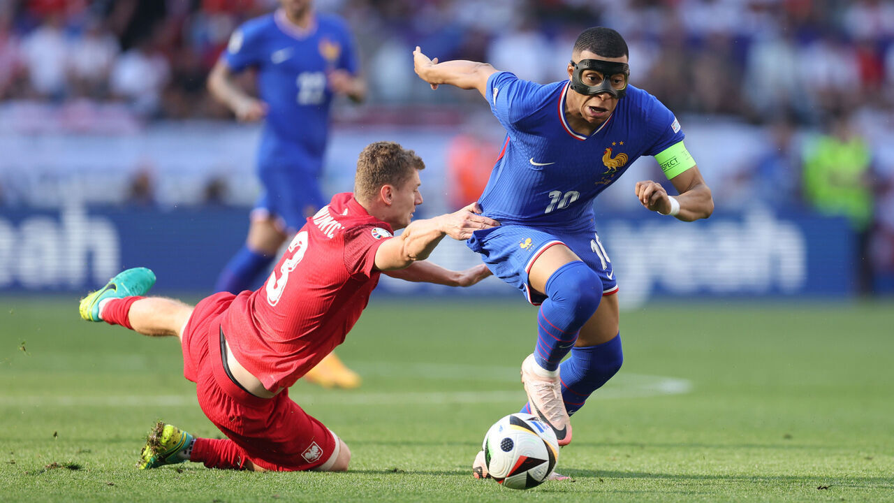 DORTMUND, GERMANY - JUNE 25: Kylian Mbappe of France in action with Pawel Dawidowicz of Poland during the UEFA EURO 2024 group stage match between France and Poland at Football Stadium Dortmund on June 25, 2024 in Dortmund, Germany.