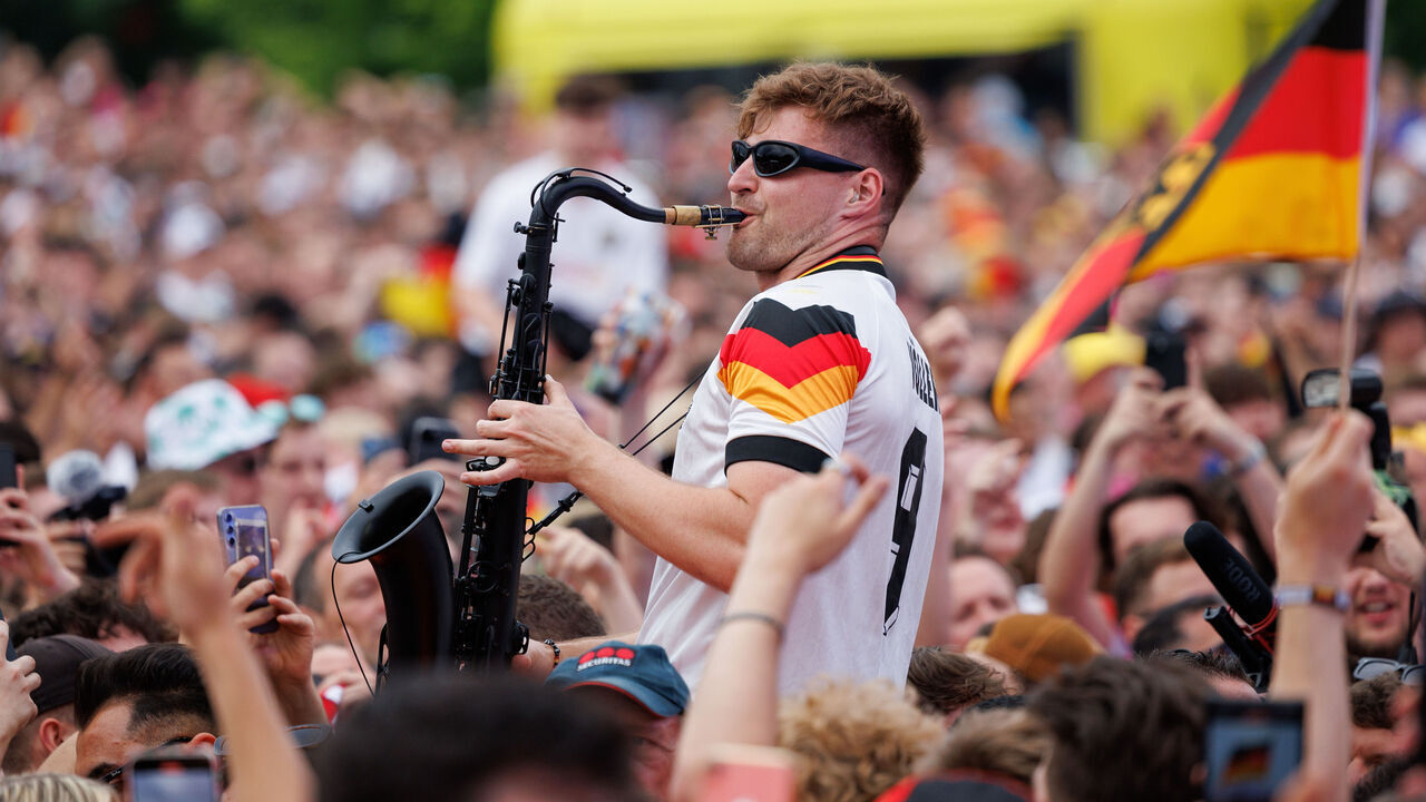 dpatop - 29 June 2024, North Rhine-Westphalia, Dortmund: Soccer, UEFA Euro 2024, European Championship, Germany - Denmark, final round, round of 16, saxophonist Andre Schura plays at the fan festival in the Fanzone Dortmund. Photo: Friso Gentsch/dpa