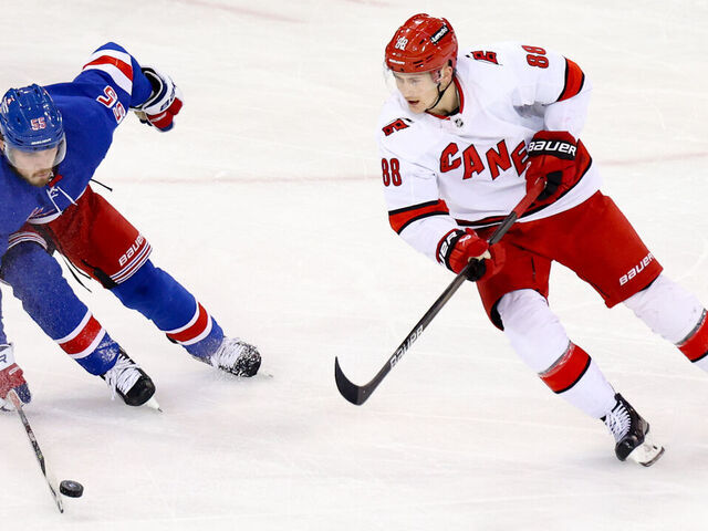 NEW YORK, NY - JANUARY 02: New York Rangers Defenseman Ryan Lindgren (55) blocks a pass by Carolina Hurricanes Right Wing Martin Necas (88) during the third period of the National Hockey League game between the Carolina Hurricanes and the New York Rangers on January 2, 2024 at Madison Square Garden in New York, NY.